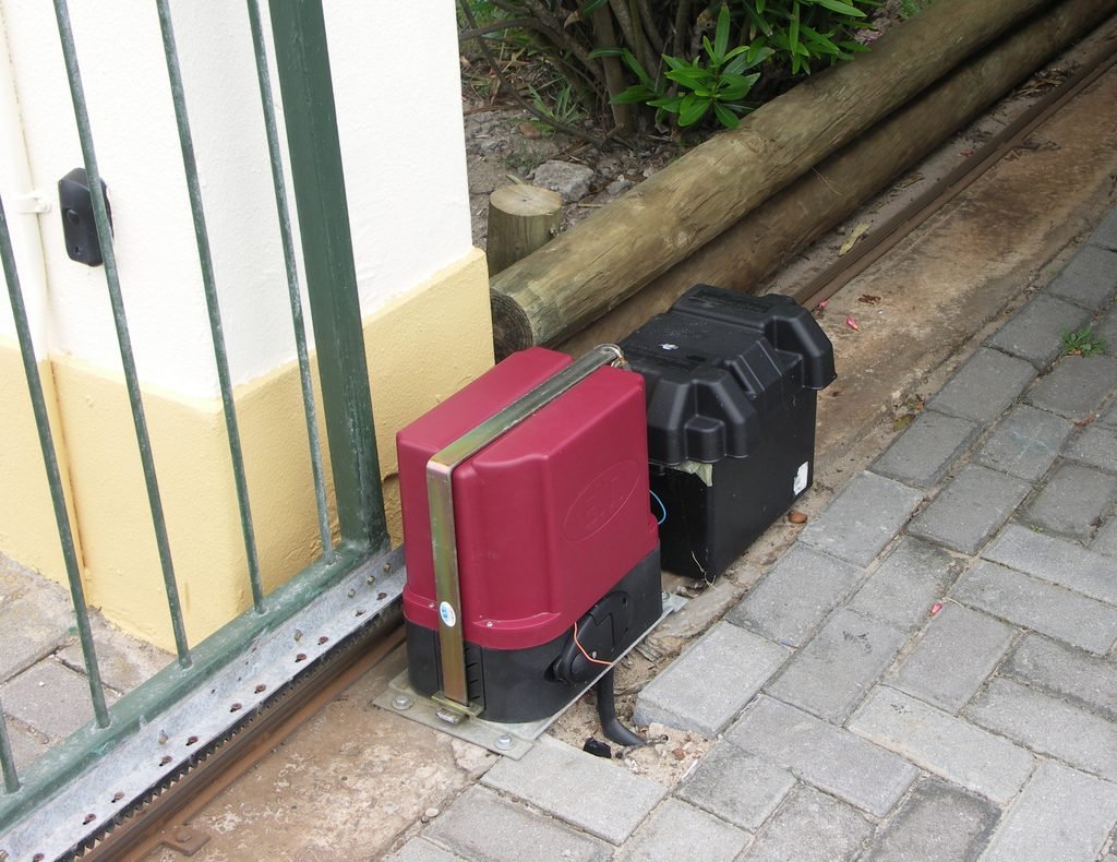 Automatic sliding gate motor installed beside a gate track 